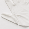 Detailopname van de gladde duimaanzet en natuurlijke plooien van een witte nitril handschoen. 