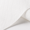 Macrodetail van Euro Toptex Snow White Z-Fold handdoekpapier met focus op de fijne papierstructuur, zachte reliëfprint en hoogwaardige afwerking op een witte achtergrond.