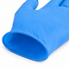 Detailopname van een blauwe disposable nitrilhandschoen met focus op de gerolde manchet en de fijne materiaalstructuur. De close-up toont de soepele, elastische afwerking van de polsopening en de lichte textuur van het nitrilmateriaal. De handschoen biedt