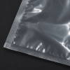 Close-up detailfoto van een transparante krimpzak met bodemseal, waarbij de stevige gesealde randen, glanzende afwerking en heldere kunststofstructuur zichtbaar zijn.