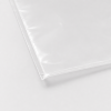 Ingezoomde detailfoto van de afgesloten onderhoek van een transparante gladde vacuümzak van 400 × 700 mm, waarbij de rechte lasnaad, zijnaad en dunne folie duidelijk zichtbaar zijn tegen een lichtgrijze achtergrond.