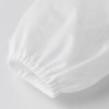Detailfoto van de elastische manchet van een witte PP bezoekersjas van non-woven materiaal.