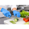 Medewerker draagt blauwe disposable nitrilhandschoenen tijdens het snijden van een komkommer op een snijplank in een professionele voedselbereidingsomgeving. De handschoenen sluiten nauw aan op de handen en bieden optimale grip, flexibiliteit en hygiëne t