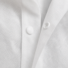 Close-up van de drukknoopsluiting en het non-woven materiaal van een witte PP bezoekersjas.