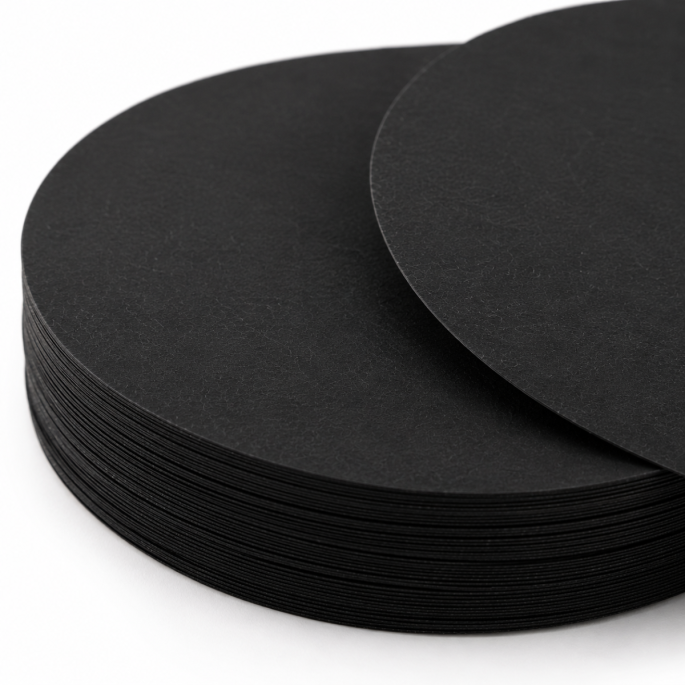 Detailfoto van Meat Saver papier 65 g/m² rond zwart Ø 120 mm met focus op de gestapelde randen en de fijne papiervezelstructuur. De close-up benadrukt de uniforme afwerking, materiaaldikte en professionele kwaliteit van het absorberende verpakkingspapier.