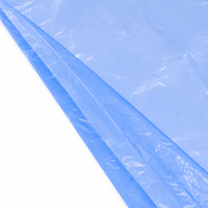 Ingezoomde detailfoto van een lege blauwe HDPE-kratzak van 10 micron, waarbij de dunne doorschijnende folie, fijne kreukels en overlappende zijvouw duidelijk zichtbaar zijn tegen een witte achtergrond.
