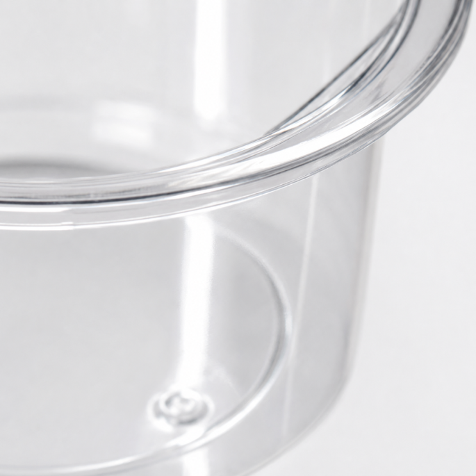 Extreme macro-opname van een transparant PP sausbakje van 30 ml. De detailfoto toont de verstevigde bovenrand, de heldere kunststofstructuur en de hoogwaardige afwerking van het bakje op een witte achtergrond.