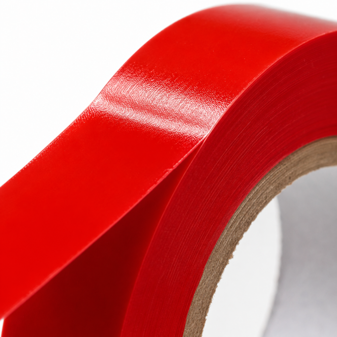 Extreme close-up van rood PVC sluit tape met focus op de glanzende afwerking, materiaalstructuur en flexibele tape-opbouw.