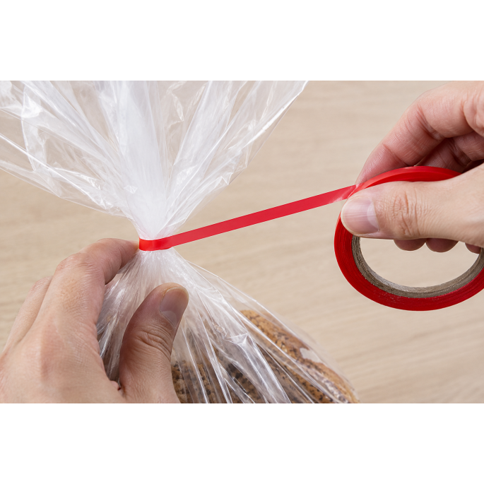 Rood PVC sluit tape in gebruik voor het sluiten van een kunststof verpakking met handmatige applicatie.